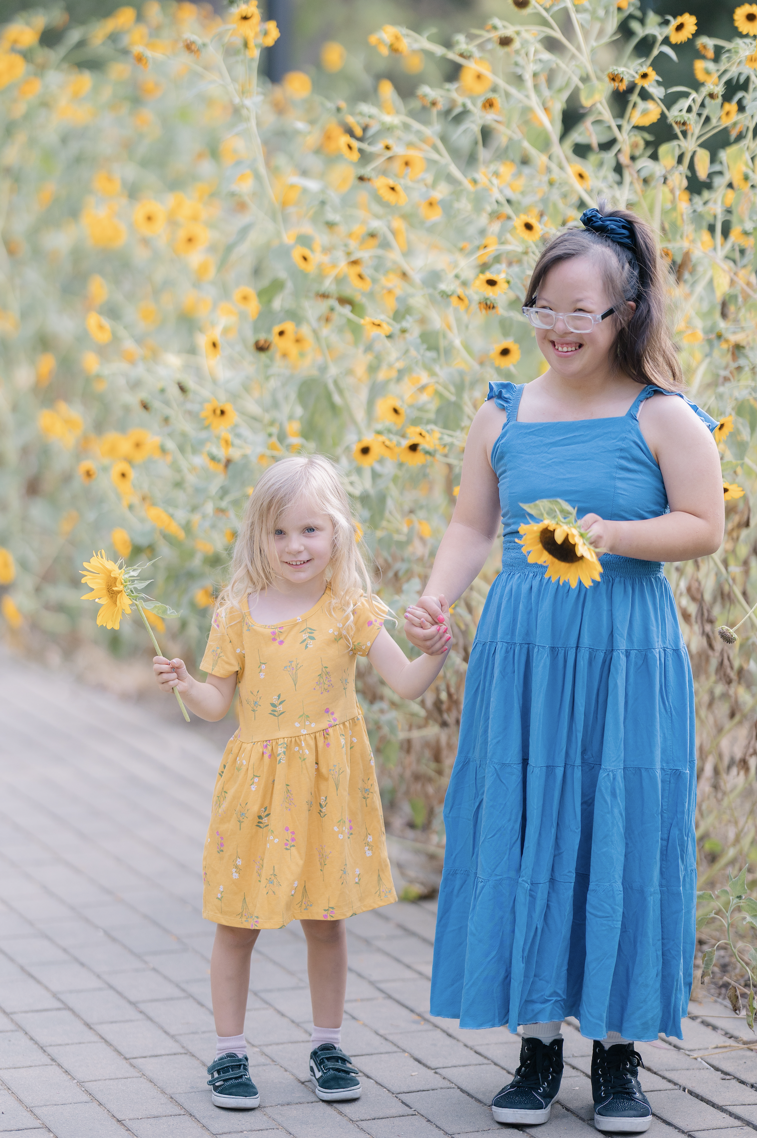 Two girls sharing a sunflower — community and inclusion in Davis